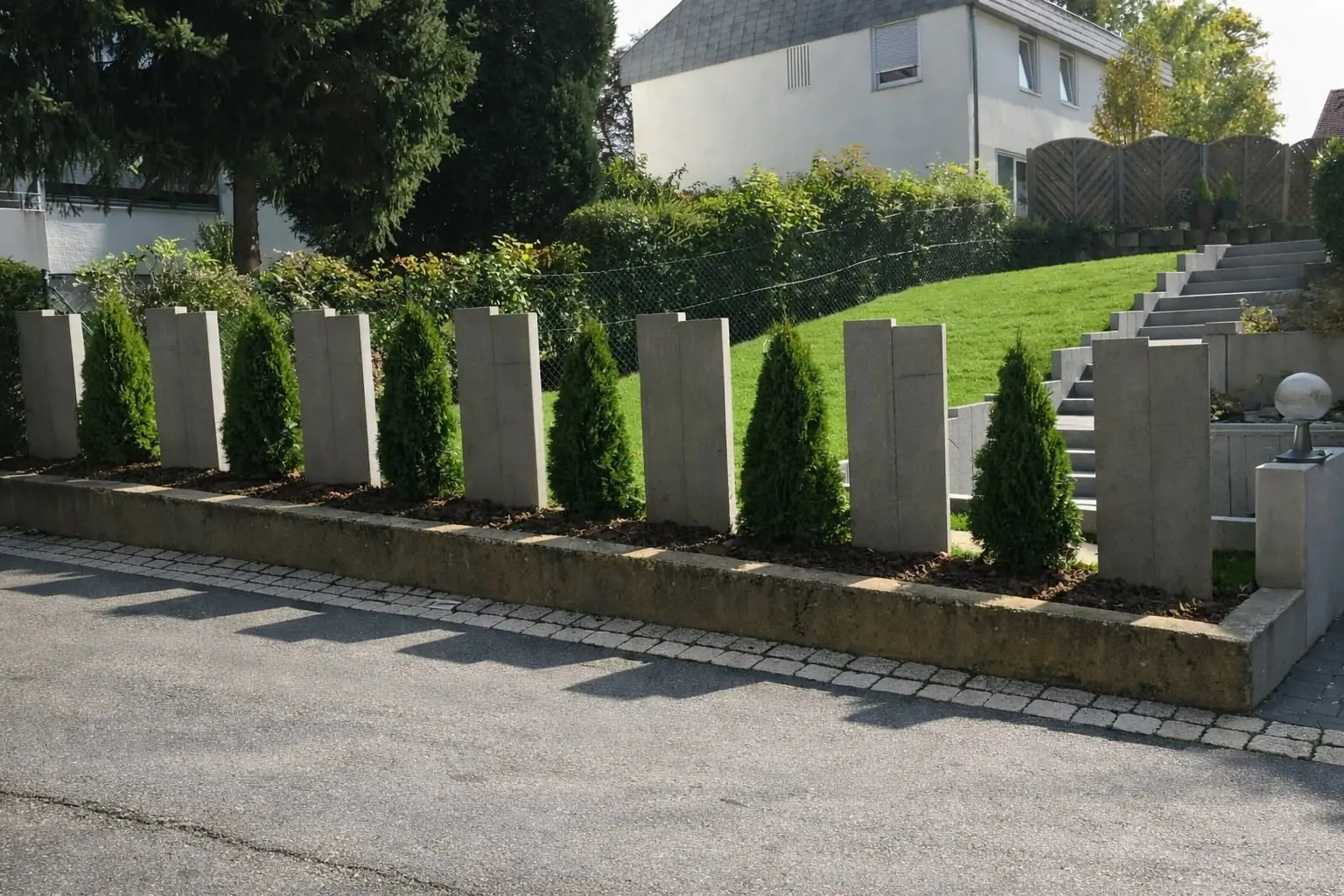 Moderne Sichtschutz-Stelen mit gepflanzten Zypressen und Pflasterstreifen